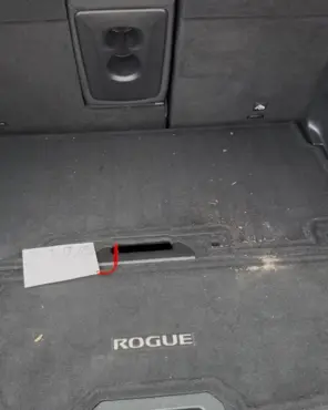 Nissan Rogue cargo area with litter and crumbs across the carpet liner